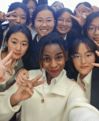 Female teacher surrounded by a group of students in China 