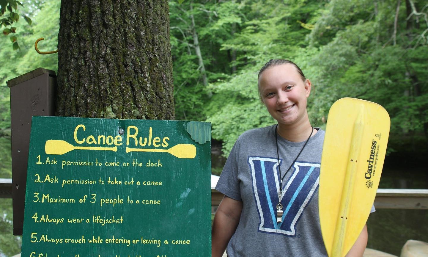 Girl holding a canoe paddle at a summer camp in the USA