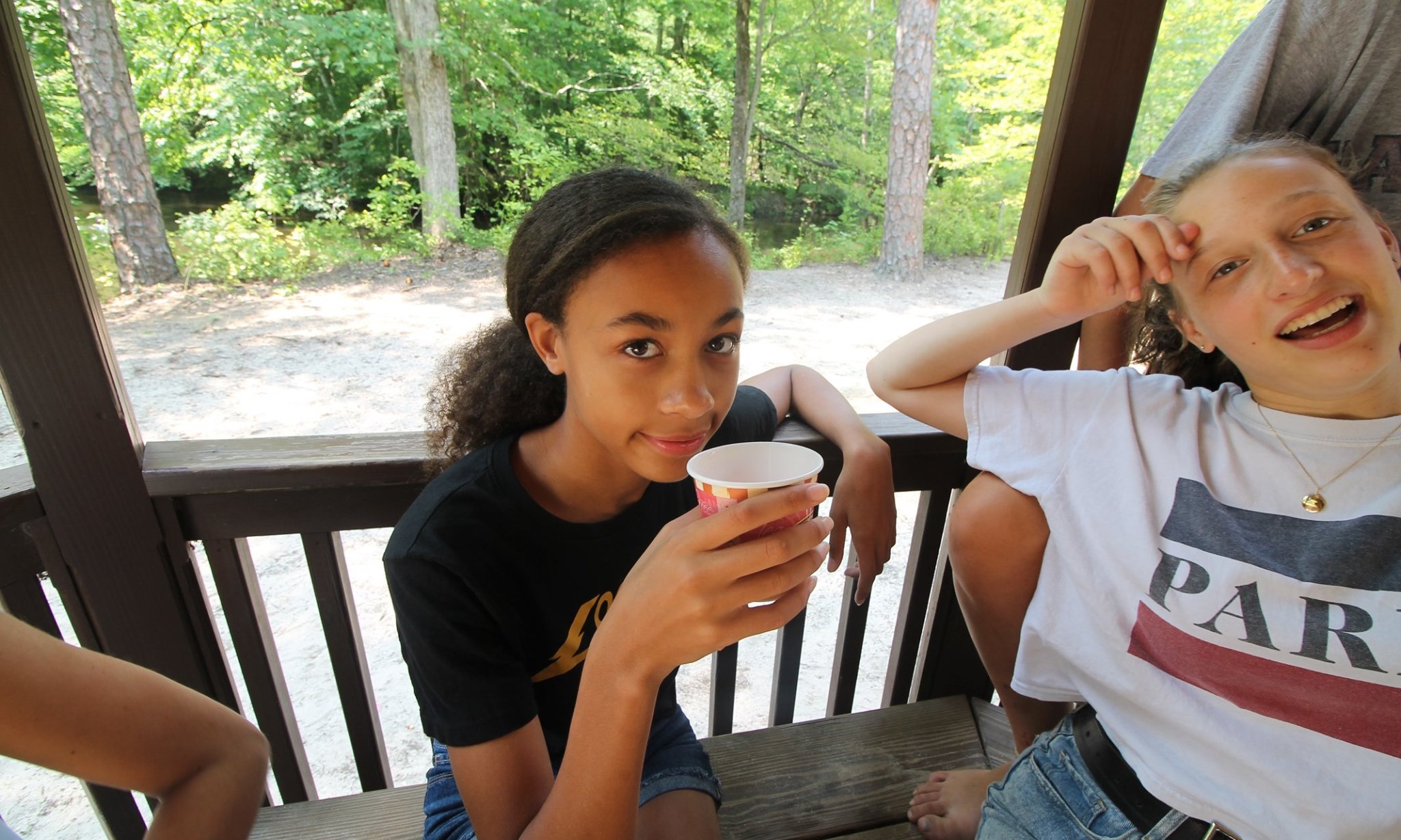 Two girls smiling and sitting at a bench in the USA