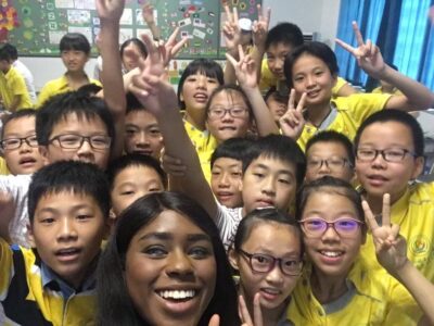 English teacher surrounded with a group of smiling students in China 
