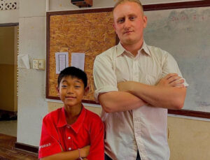 Student and English teacher in Thailand doing a funny pose with folded arms in the classroom. 
