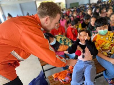 Teacher hands an excited and stunned student the microphone 