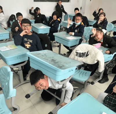 Students in China smiling and messing around in their classroom 