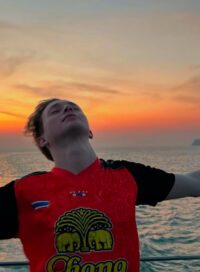 Man closing his eyes and smiling near the beach