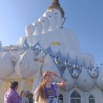 A woman smiling near a temple in Thailand